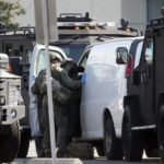 
              Members of a SWAT team enter a van and look through its contents in Torrance Calif., Sunday, Jan. 22, 2023. An hours-long manhunt led police to surround and enter the van. Authorities say the suspect in a California dance club shooting that left multiple people dead, shot and killed himself. (AP Photo/Damian Dovarganes)
            