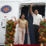 
              Philippine President Ferdinand Marcos Jr., right, waves beside wife Maria Louise as they board a plane for China on Tuesday, Jan. 3, 2023, at the Villamor Air Base in Manila, Philippines. (AP Photo/Aaron Favila)
            