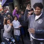 
              Darius Conner, son of business owner Roland, speaks to waiting customers and media members outside the Smacked "pop up" cannabis dispensary location they operate, Tuesday, Jan. 24, 2023, in New York. The store is the first Conditional Adult-Use Retail Dispensary (CAURD) opening since the legalization of cannabis that is run by businesspeople who had been criminalized by cannabis prohibition. (AP Photo/John Minchillo)
            