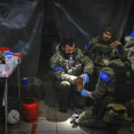 Ukrainian servicemen administer first aid to a wounded soldier in a shelter in Soledar, the site of heavy battles with Russian forces in the Donetsk region, Ukraine, Sunday, Jan. 8, 2023. (AP Photo/Roman Chop)