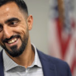 
              Abdul Wasi Safi smiles after a news conference Friday, Jan. 27, 2023, in Houston. Wasi Safi, an intelligence officer for the Afghan National Security Forces who fled Afghanistan following the withdrawal of U.S. forces, was freed this week and reunited with his brother after spending months in immigration detention. (AP Photo/David J. Phillip)
            