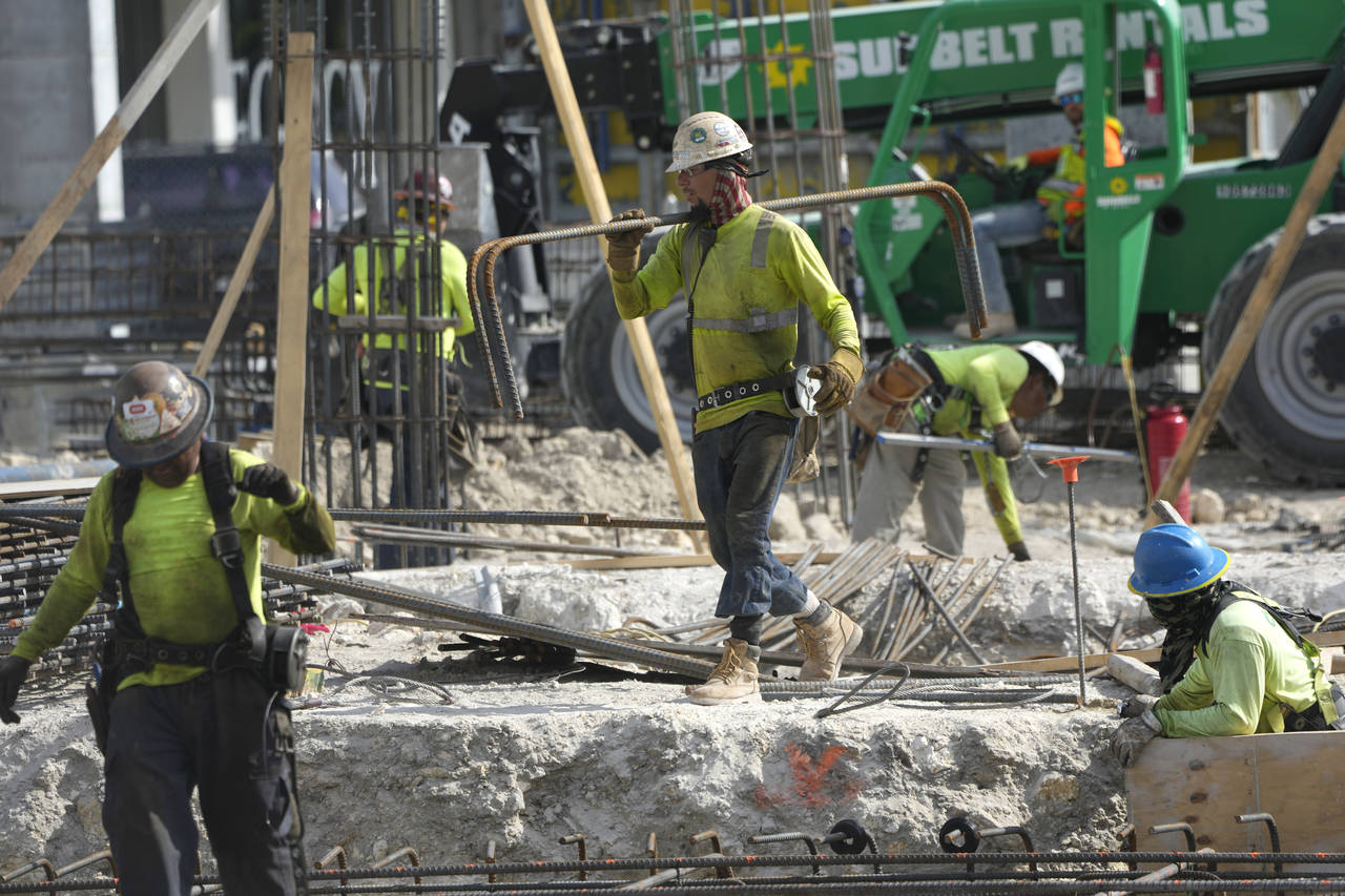 People work at a construction site, Tuesday, Jan. 24, 2023, in Miami. On Tuesday, the Labor Departm...