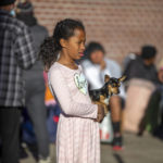 
              A migrant child holds her dog while camping outside the Sacred Heart Church in downtown El Paso, Texas, Sunday, Jan. 8, 2023. President Joe Biden arrived in Texas on Sunday for his first trip to the U.S.-Mexico border since taking office, stopping in El Paso after two years of hounding by Republicans who have hammered him as soft on border security while the number of migrants crossing spirals. (AP Photo/Andres Leighton)
            
