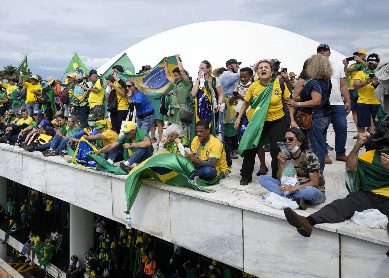 FILE - Protesters, supporters of Brazil's former President Jair Bolsonaro, stand on the roof of the...