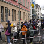 
              FILE - People from Ukraine, most of them refugees fleeing the war, wait in front of the consular department of the Ukrainian embassy in Berlin, Germany, on April 6, 2022. More than 244,000 people applied for asylum in Germany last year, and more than 1 million Ukrainian refugees came to the country looking for shelter from Russia's war, the government said Wednesday Jan. 11, 2023. (AP Photo/Markus Schreiber, File)
            
