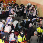 
              FILE - Rescue workers treat injured people on the street near the scene of a crowd surge in Seoul, South Korea, on Oct. 30, 2022. South Korean police on Friday, Jan. 13, 2023, said they are seeking charges of involuntary manslaughter and negligence against 23 officials, for a lack of safety measures they said were responsible for a crowd surge that killed nearly 160 people in October. (AP Photo/Lee Jin-man, File)
            