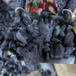 
              FILE - A woman works at a coal depot in Ahmedabad, India, May 2, 2022. Fossil fuels generate more than 70% of India’s electricity and have been doing so for decades. Coal is by far the largest share of dirty fuels. (AP Photo/Ajit Solanki, File)
            