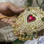 
              Deity decorator S. Goutham holds a specially crafted piece of jewelry that would adorn the chest of the goddess Durga at the Anantha Padmanabha Swamy Temple in Chennai, India, on Nov. 29, 2022. He says the jewels and weapons on a deity tell a story and give each decoration its unique personality and character. (AP Photo/Deepa Bharath)
            