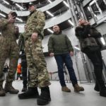 
              FILE - Visitors wearing military camouflage talk in the 'PMC Wagner Centre', which is associated with businessman and founder of the Wagner private military group Yevgeny Prigozhin, during the official opening of the office block during National Unity Day, in St. Petersburg, Russia, on Nov. 4, 2022. Russia's Wagner Group, a private military company led by Yevgeny Prigozhin, a rogue millionaire with longtime links to Russia's President Vladimir Putin, has played an increasingly visible role in the fighting in Ukraine. (AP Photo, File)
            