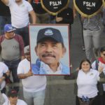 
              A man marches holding a portrait of President Daniel Ortega during a pro-government march in Managua, Nicaragua, Saturday, Feb. 11, 2023.  (AP Photo)
            