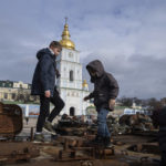 
              Children stand atop of a destroyed Russian vehicle in the city center of Kyiv, Ukraine, Thursday, Feb. 2, 2023. (AP Photo/Evgeniy Maloletka)
            