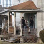 
              An Ohio state trooper goes door to door telling residents to leave downtown East Palestine, Ohio, on Sunday, Feb. 5, 2023. A smoldering tangle of dozens of derailed freight cars, some carrying hazardous materials, has kept an evacuation order in effect in Ohio near the Pennsylvania state line as environmental authorities warily watch air quality monitors. (Lucy Schaly/Pittsburgh Post-Gazette via AP)
            