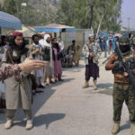 FILE - A Pakistani paramilitary soldier, left, and Taliban fighters stand guard on their respective sides, at a border crossing point between Pakistan and Afghanistan, in Torkham, in Khyber district, Pakistan, on Sept. 5, 2021. The main crossing on the Afghan-Pakistan border remained shut Tuesday, Feb. 21, 2023, for the third straight day, officials said, after Afghanistan's Taliban rulers earlier this week closed the key trade route and exchanged fire with Pakistani border guards. (AP Photo/Qazi Rauf, File)