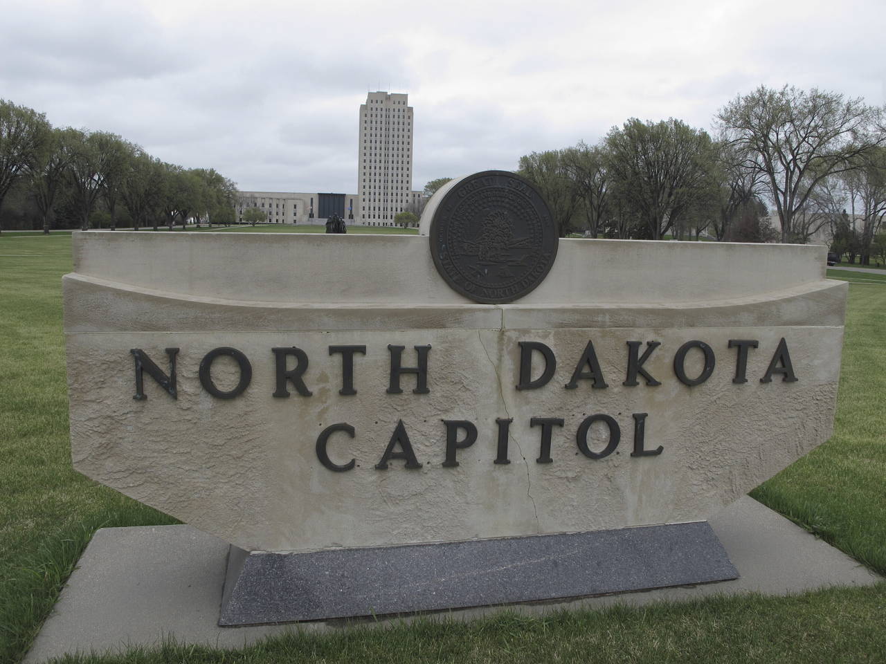 FILE- The North Dakota Capitol tower rises in the background behind a stone signe, April 19, 2012, ...
