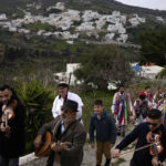 
              Local residents wearing folk costumes parade during a traditional custom called Kordelatoi, in the village of Kourounochori, on the Aegean Sea island of Naxos, Greece, on Saturday, Feb. 25, 2023. The first proper celebration of the Carnival after four years of COVID restrictions, has attracted throngs of revellers, Greek and foreign, with the young especially showing up in large numbers. (AP Photo/Thanassis Stavrakis)
            