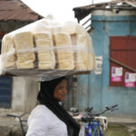 
              A woman sells bread on a street in Lagos, Nigeria, on Friday, Feb. 3, 2023. Nearly a year after Russia invaded Ukraine, the global economy is still enduring the consequences — crunched supplies of grain, fertilizer and energy along with more inflation and economic insecurity. One official in Nigeria said, “A lot of people have stopped eating bread; they have gone for alternatives because of the cost.’’ (AP Photo/Sunday Alamba)
            