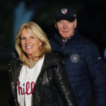 
              FILE - First lady Jill Biden wears a Philadelphia Phillies jersey as she and President Joe Biden walk on the South Lawn of the White House after stepping off Marine One, Oct. 23, 2022, in Washington. (AP Photo/Patrick Semansky, File)
            