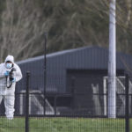 
              A forensic investigator from Police Service of Northern Ireland (PSNI) at the sports complex in the Killyclogher Road area of Omagh, Co Tyrone, Northern Ireland Thursday, Feb. 23, 2023 where off-duty PSNI Detective Chief Inspector John Caldwell was shot. A senior Northern Ireland police officer is in critical but stable condition in a hospital after being shot by two masked men while he coached children’s soccer. Police said Thursday that a dissident Irish Republican Army splinter group is suspected of shooting the detective at a sports complex in the town of Omagh on Wednesday night.  (Liam McBurney/PA via AP)
            