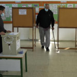 A man leaves the booth as he casts a vote during the presidential election in Geroskipou in southwest coastal city of Paphos, Cyprus, Sunday, Feb. 12, 2023. Voting has started in a runoff to elect ethnically split Cyprus' eighth new president, pitting a former foreign minister who campaigned as a unifier eschewing ideological and party divisions against a popular veteran diplomat. (AP Photo/Petros Karadjias)