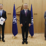 
              FILE - Finland's Ambassador to NATO Klaus Korhonen, left, NATO Secretary-General Jens Stoltenberg and Sweden's Ambassador to NATO Axel Wernhoff attend a ceremony to mark Sweden's and Finland's application for membership in Brussels, Belgium, Wednesday May 18, 2022. (Johanna Geron/Pool via AP, File)
            