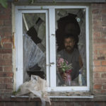 
              FILE - A local resident places a vase with flowers on a broken window in his house damaged by the Russian shelling in Bakhmut, Donetsk region, Ukraine, Sunday , June 26, 2022.(AP Photo/Efrem Lukatsky, File)
            