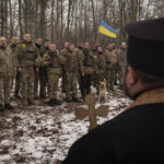 FILE - A priest blesses Ukrainian servicemen of the Prince Roman the Great 14th Separate Mechanized Brigade as they stand in formation during a flag ceremony where some of them were honored for their bravery and accomplishments in battle, in the Kharkiv area, Ukraine, Saturday, Feb. 25, 2023. Grueling artillery battles have stepped up in recent weeks in the vicinity of Kupiansk, a strategic town on the eastern edge of Kharkiv province by the banks of the Oskil River as Russian attacks intensifying in a push to capture the entire industrial heartland known as the Donbas, which includes the Donetsk and the Luhansk provinces. (AP Photo/Vadim Ghirda, File)