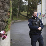 
              A police officer guards the entrance to a private Catholic school next to a bouquet of flowers after a teacher of Spanish has been stabbed to death by a high school student, Wednesday, Feb. 22, 2023 in Saint-Jean-de-Luz, southwestern France. The student has been arrested by police, the prosecutor of Bayonne said. (AP Photo/Bob Edme)
            
