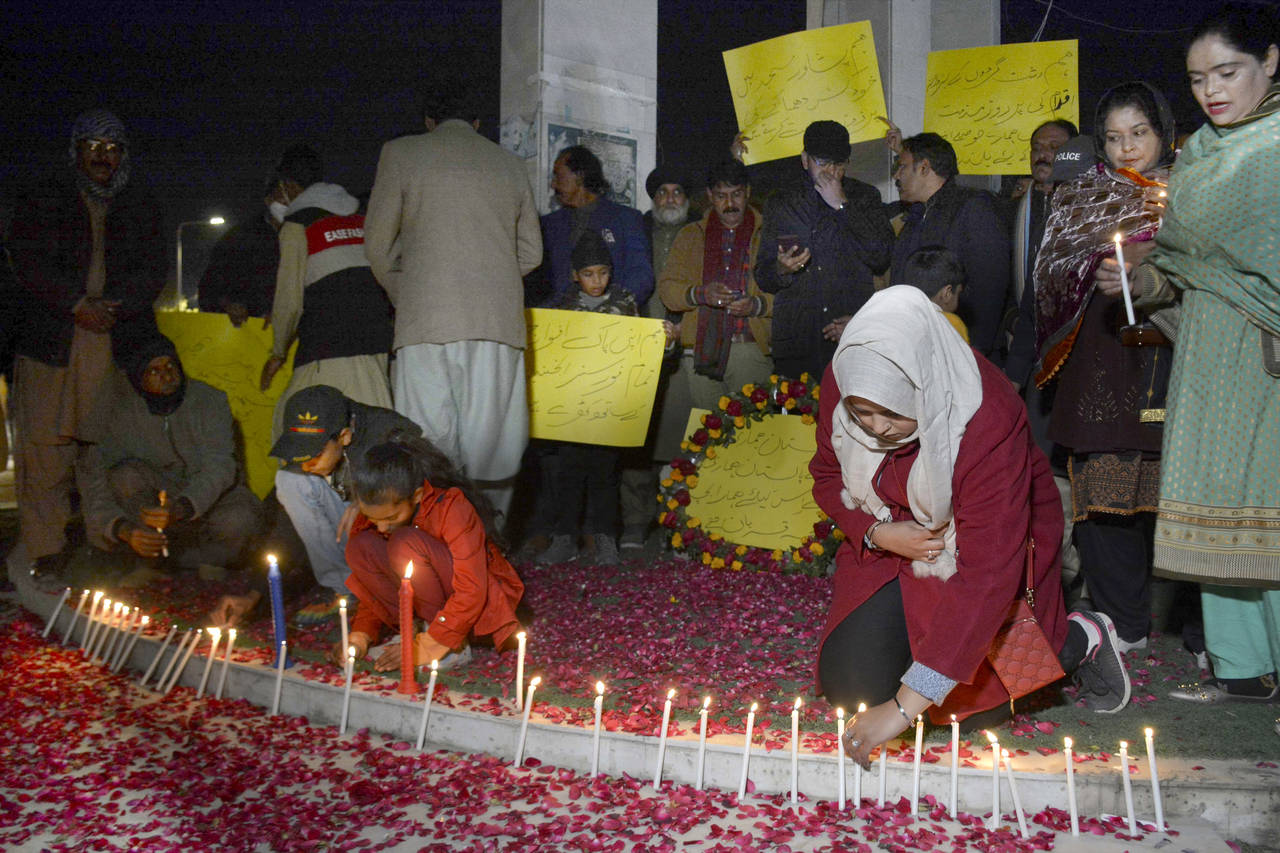 Children light candle as they with other take part in a candle light vigil for the victims of Monda...