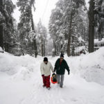 
              Angie Gourirand, right, and Cindy Maner, whose cars are buried in the snow, carry their groceries on a sled in Running Springs, Calif., Tuesday, Feb. 28, 2023. Beleaguered Californians got hit again Tuesday as a new winter storm moved into the already drenched and snow-plastered state, with blizzard warnings blanketing the Sierra Nevada and forecasters warning residents that any travel was dangerous. (AP Photo/Jae C. Hong)
            