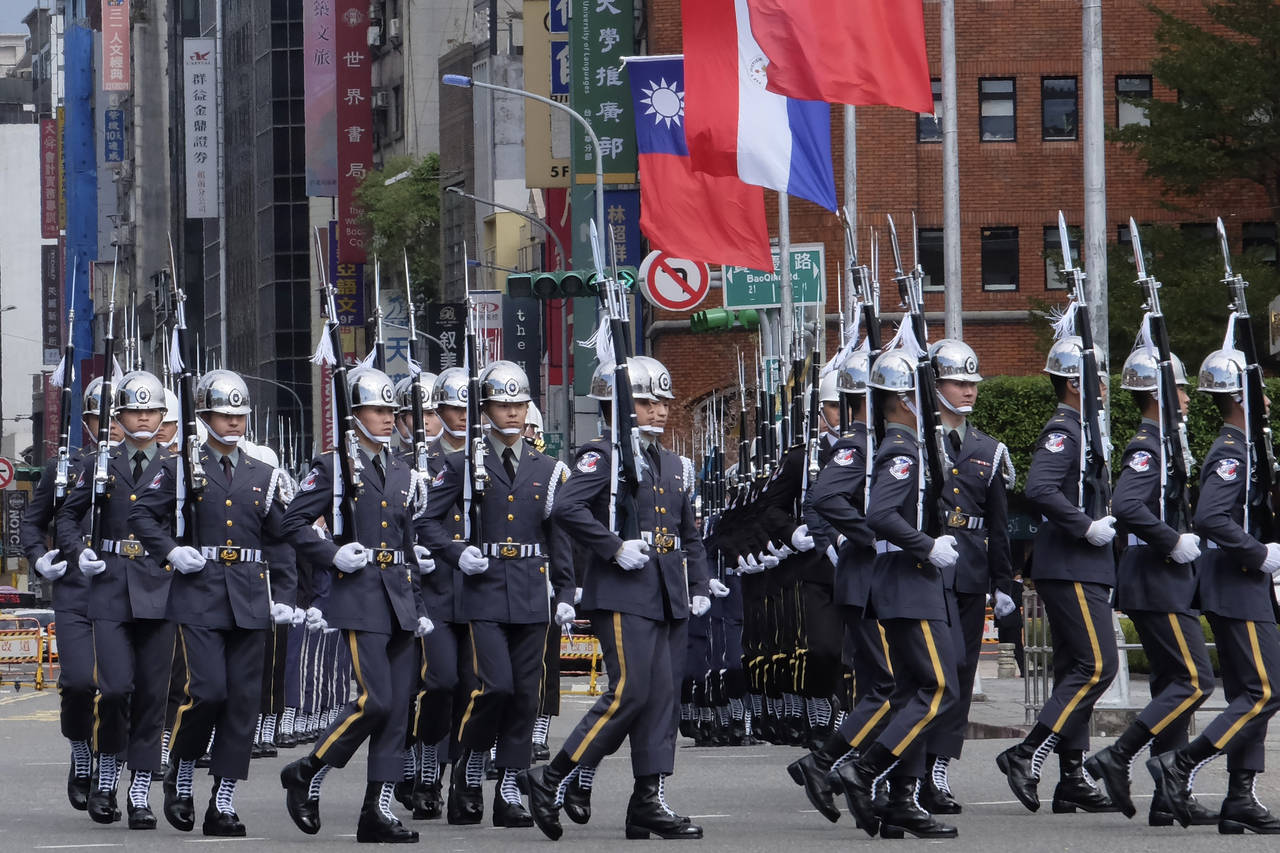 Members of an honor guard march in formation near Taiwanese and Paraguayan flags at the Presidentia...