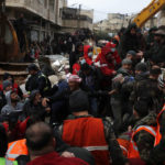 
              Civil defense workers and security forces carry an earthquake victim as they search through the wreckage of collapsed buildings in Hama, Syria, Monday, Feb. 6, 2023. A powerful earthquake has caused significant damage in southeast Turkey and Syria and many casualties are feared. Damage was reported across several Turkish provinces, and rescue teams were being sent from around the country. (AP Photo/Omar Sanadik)
            