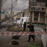 
              FILE - Police officers inspect area after an apparent Russian strike in Kyiv Ukraine, Thursday, Feb. 24, 2022.  (AP Photo/Emilio Morenatti, File)
            