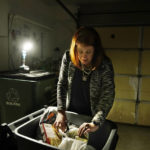
              Leah Thomas looks over her disposed food items, Monday, Feb. 27, 2023, in Beverly Hills in Oakland County, Mich. Thomas, whose home north of Detroit lost power Wednesday night, was still waiting Monday afternoon for the power to come back. (AP Photo/Carlos Osorio)
            