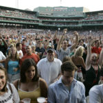 
              FILE — Fans stand as singer Dave Matthews takes the stage during a concert at Fenway Park, in Boston, July 7, 2006. Fenway Park has kept busy in the offseason with hockey, football and other events that have turned one of baseball's crown jewels into a year-round venue. (AP Photo/Charles Krupa, File)
            