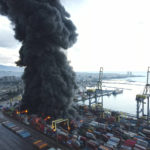 
              Smoke rises from burning containers at the port in the earthquake-stricken town of Iskenderun, southern Turkey, Tuesday, Feb. 7, 2023. Television images on Tuesday showed thick black smoke rising from burning containers at Iskenderun Port. Reports said the fire was caused by containers that toppled over during the powerful earthquake that struck southeast Turkey on Monday. Turkey's state-run Anadolu Agency said a Turkish Coast Guard vessel was assisting efforts to extinguish fire. (Serdar Ozsoy/Depo Photos via AP)
            