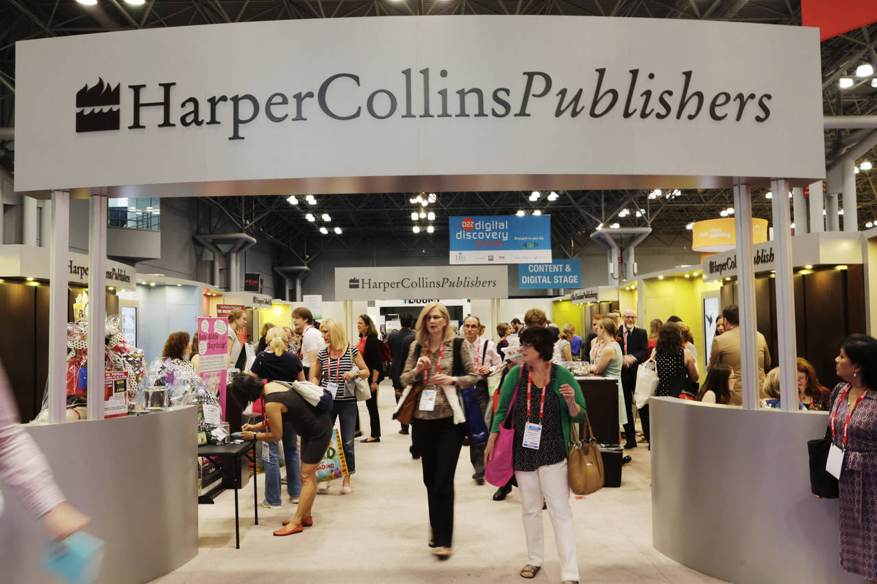 FILE - Attendees at BookExpo America visit the HarperCollins Publishers booth in New York on May 28...