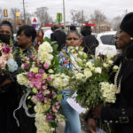 
              Mourners hold flowers after a funeral for Michigan State University shooting victim Arielle Anderson in Detroit, Tuesday, Feb. 21, 2023. Anderson, Alexandria Verner and Brian Fraser and were killed and several other students injured after a gunman opened fire on the campus of Michigan State University. (AP Photo/Paul Sancya)
            