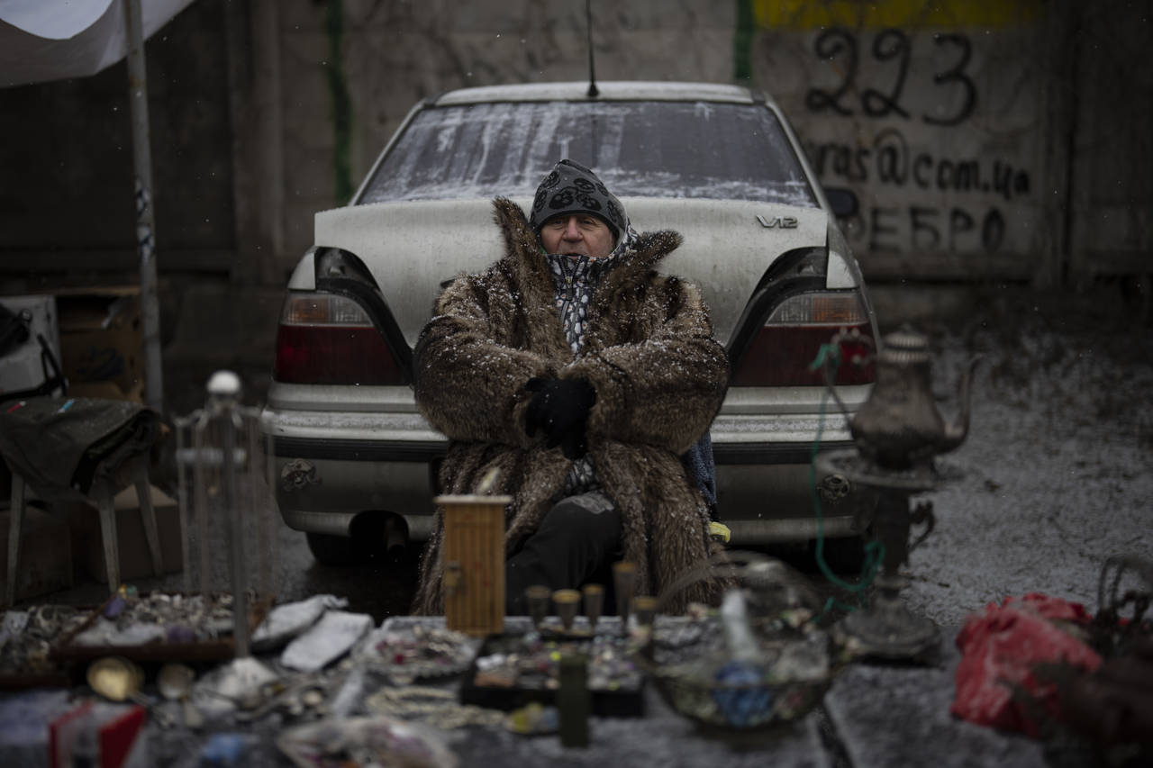A vendor sits at a flea market in Kyiv, Ukraine, Saturday, Feb. 4, 2023. (AP Photo/Daniel Cole)...