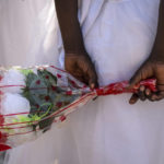 
              A young girl holds a bunch of flowers behind her back as she awaits the arrival of Pope Francis at the St. Theresa Cathedral in Juba, South Sudan, Saturday, Feb. 4, 2023. Pope Francis is in South Sudan on the second leg of a six-day trip that started in Congo, hoping to bring comfort and encouragement to two countries that have been riven by poverty, conflicts and what he calls a "colonialist mentality" that has exploited Africa for centuries. (AP Photo/Ben Curtis)
            