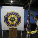 
              A staff member arranges banners beside the Philippine and U.S. flag at the American Legion Post 4 just outside what used to be America's largest overseas naval base at Olongapo city, Zambales province, northwest of Manila, Philippines on Monday Feb. 6, 2023. The U.S. has been rebuilding its military might in the Philippines after more than 30 years and reinforcing an arc of military alliances in Asia in a starkly different post-Cold War era when the perceived new regional threat is an increasingly belligerent China. (AP Photo/Aaron Favila)
            