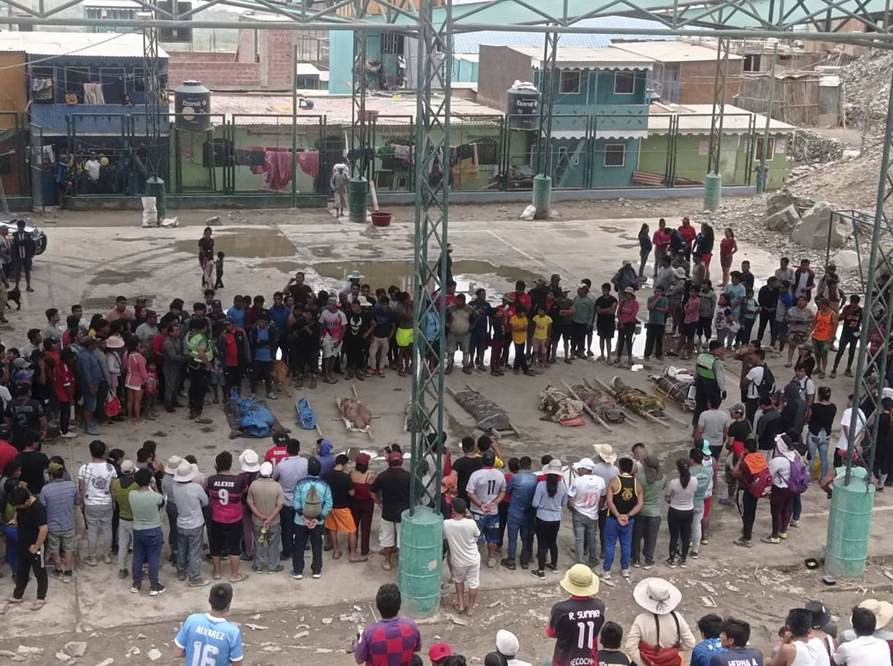 Residents stand around the bodies of persons who perished in recent landslides in Camana, Peru, Mon...