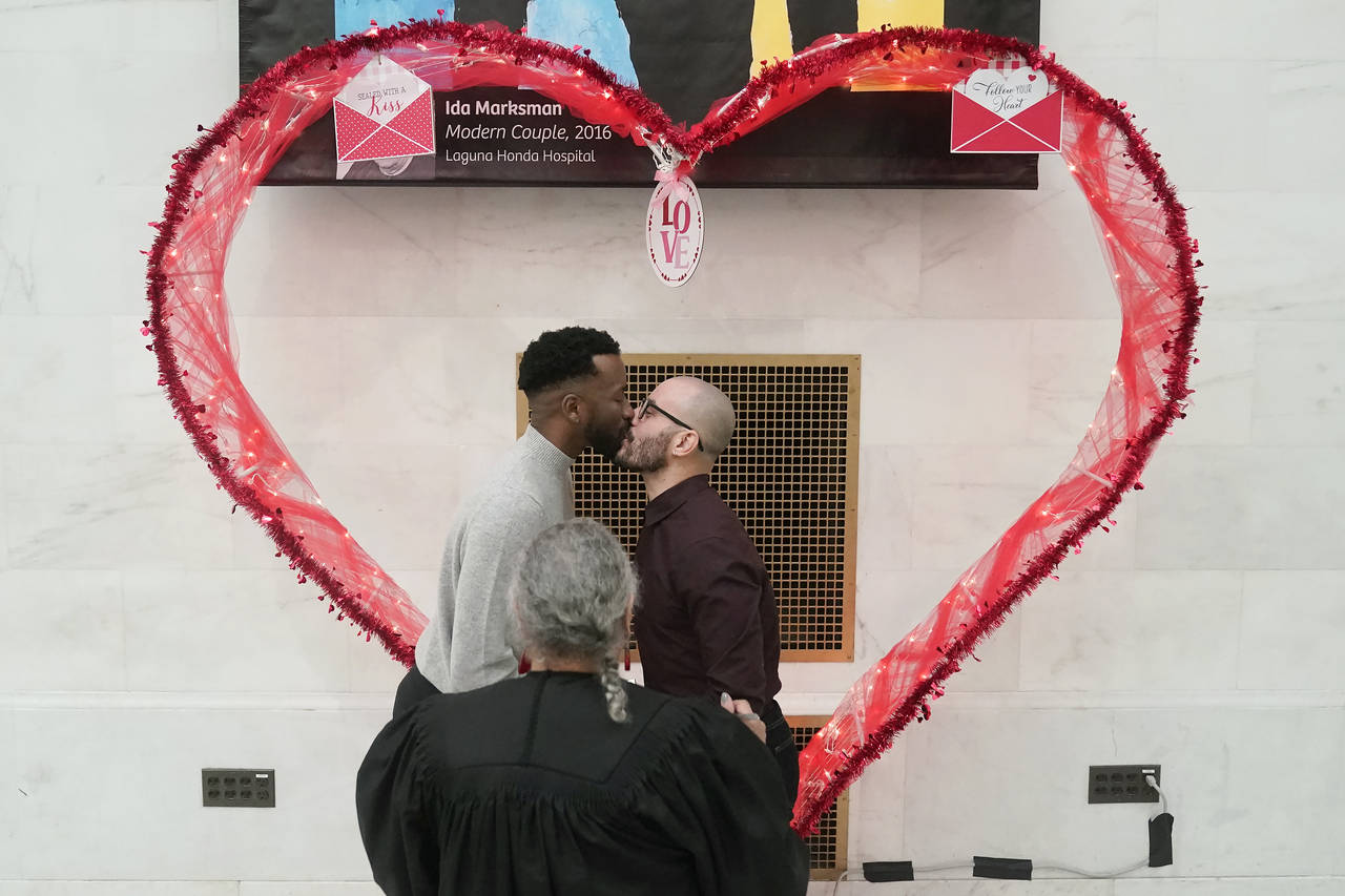 Jeremy Yancey, left, kisses Fabio de Andrade while getting married as deputy marriage commissioner ...