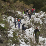 
              People walk along a trail partially covered in snow at the Deukmejian Wilderness Park, a rugged 709-acre site in the foothills of the San Gabriel Mountains, at the northernmost extremity of Glendale, Calif., Sunday, Feb. 26, 2023. (AP Photo/Damian Dovarganes)
            