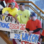 
              Union members hold signs before President Joe Biden speaks about the economy to union members at the IBEW Local Union 26, Wednesday, Feb. 15, 2023, in Lanham, Md. (AP Photo/Evan Vucci)
            