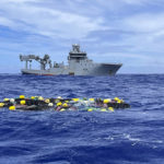 
              In this undated photo supplied by the New Zealand police, a shipment of cocaine floats on the surface of the Pacific Ocean with Royal New Zealand Navy vessel HMNZS Manawanui behind. New Zealand police said Wednesday, Feb. 8, 2023 they found more than 3 tons of cocaine floating in a remote part of the Pacific Ocean after it was dropped there by an international drug-smuggling syndicate. (NZ Police via AP)
            