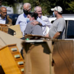 FILE - President Joe Biden hugs a person as he tours a neighborhood impacted by Hurricane Ida, Tuesday, Sept. 7, 2021, in Manville, N.J. Sen. Cory Booker, D-N.J., second from left, and New Jersey Gov. Phil Murphy, second from right, look on. (AP Photo/Evan Vucci, File)