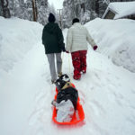 
              Angie Gourirand, left, and Cindy Maner, whose cars are buried in the snow, carry their groceries on a sled in Running Springs, Calif., Tuesday, Feb. 28, 2023. Beleaguered Californians got hit again Tuesday as a new winter storm moved into the already drenched and snow-plastered state, with blizzard warnings blanketing the Sierra Nevada and forecasters warning residents that any travel was dangerous. (AP Photo/Jae C. Hong)
            