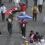 
              A person marches waving the Sandinista National Liberation Front banner and a Nicaraguan national flag march during a pro-government demonstration in Managua, Nicaragua, Saturday, Feb. 11, 2023.  (AP Photo)
            