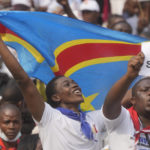 
              Two boys react as Pope Francis arrives at the Martyrs' Stadium in Kinshasa, Democratic Republic of Congo for a meeting with young people, Thursday, Feb. 2, 2023. Francis is in Congo and South Sudan for a six-day trip, hoping to bring comfort and encouragement to two countries that have been riven by poverty, conflicts and what he calls a "colonialist mentality" that has exploited Africa for centuries. Sign in Italian reads "Saints now". (AP Photo/Gregorio Borgia)
            