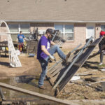 
              Jacob Young, front, and his family works to remove debris from their back yard on Monday, Feb. 27, 2023 in Norman, Okla. after a tornado passed through the area. The damage came after rare severe storms and tornadoes moved through Oklahoma overnight. (AP Photo/Alonzo Adams)
            